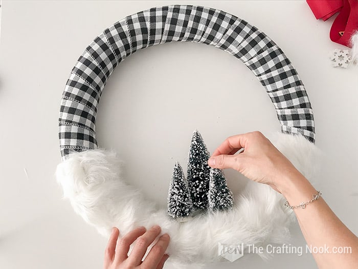 Placing the pines on the fur base of the wreath