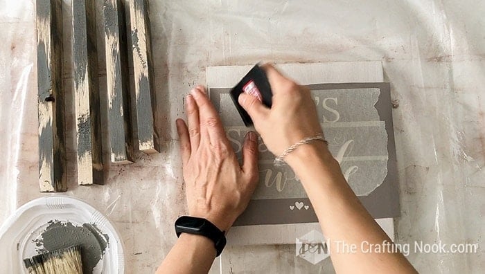 Placing the vinyl stencil as centered in wood sign board