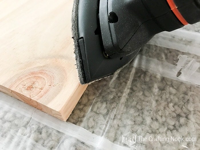 sanding the edges of wood with sander
