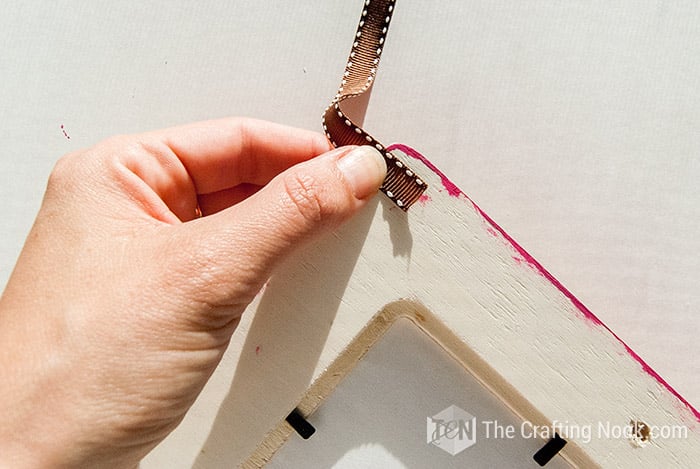 placing a strip of ribbon on the back of the frame