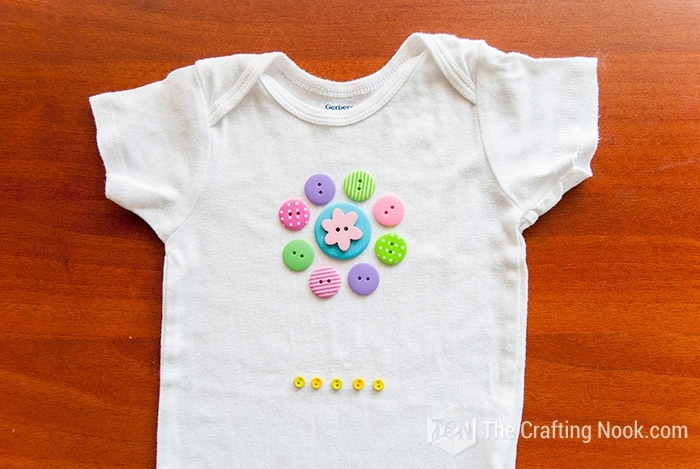 placing the buttons to visualize the design on the onesie