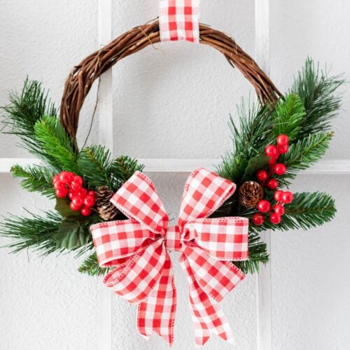 DIY Rustic Christmas Wreath in Red and White hangin on the window frame