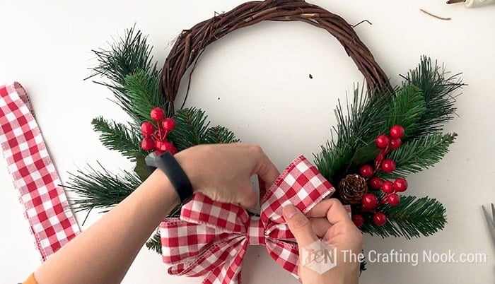 adjusting the bow on the DIY Rustic Christmas Wreath