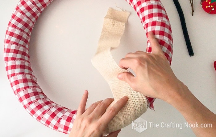 wrapping the top of the wreath with the burlap ribbon