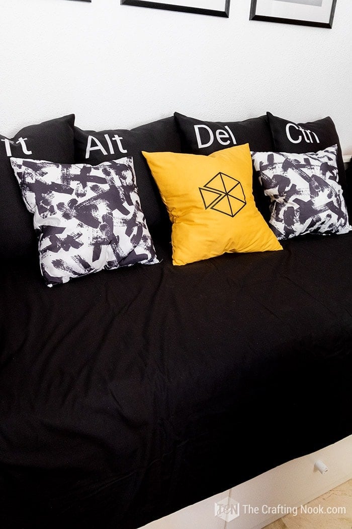 Fun Pillow covers designed with keyboard keys, 2 pillows black and white strokes design and a yellow accent pillow with our logo