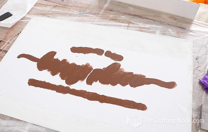 Painting the stencil with brown paint