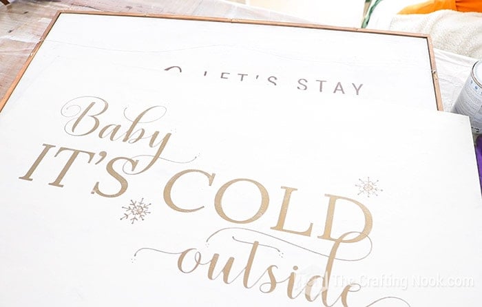 view of message "baby it´s cold outside" on wooden plank