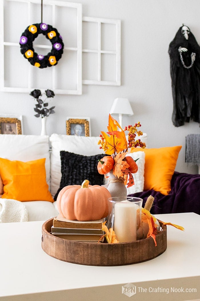 coffee table with a couple of pumpkins, old books and maple leaf arrangements