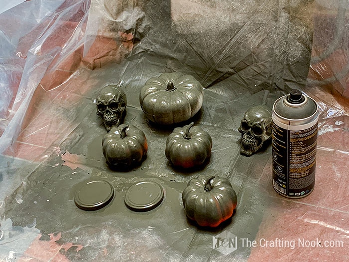 some plastic skulls and pumpkins spray painted black