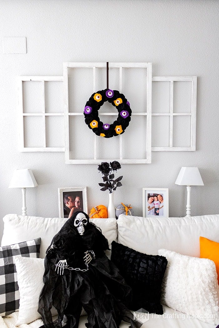 Halloween decor with the Spooky Wreath and a Halloween skull siting on the sofa