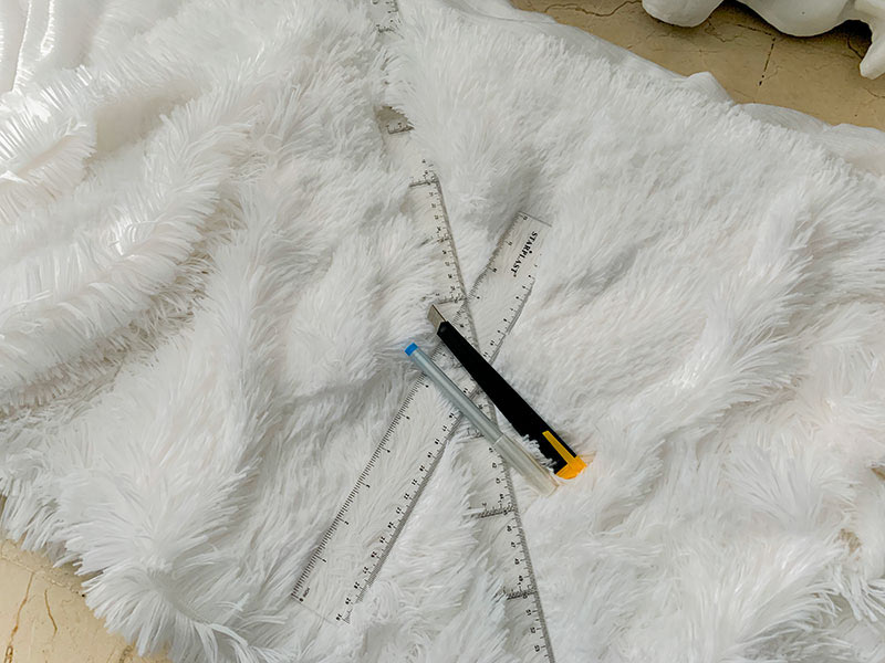 top view of rulers, pen, cutter on fur fabric