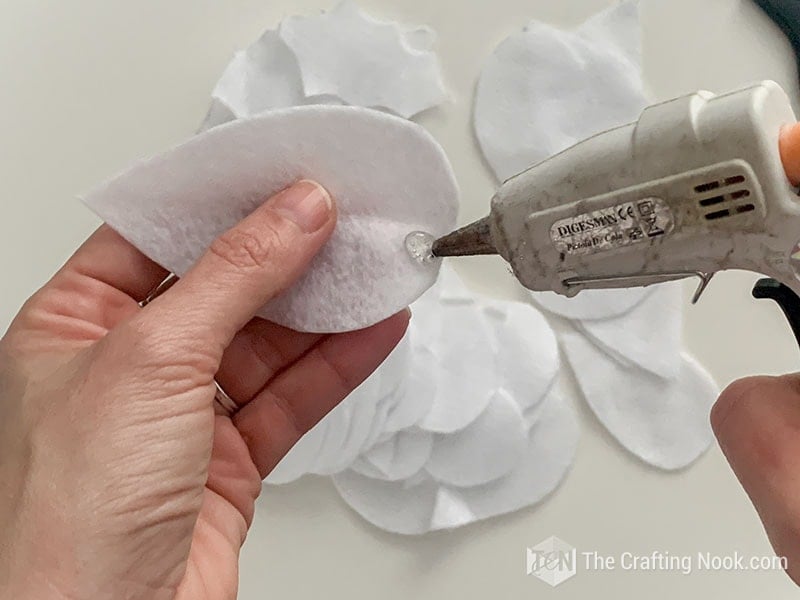 Placing hot glue on a leaf of felt
