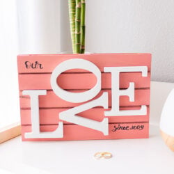 DIY Mini Pallet Wood Sign for Valentine's Day on a table behind our weeding rings