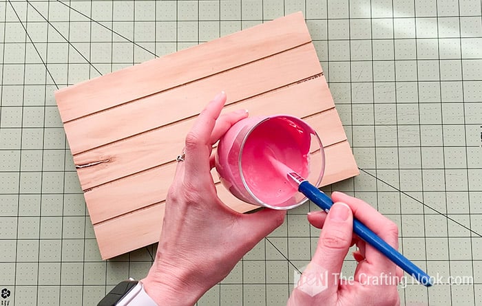 Pink paint in a glass diluting with water