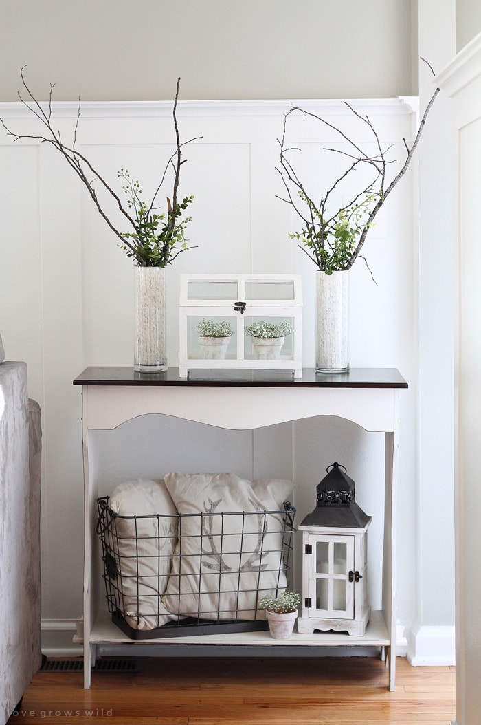 Love this table with mix of rustic lanterns, wire baskets, flowers and cozy pillows.