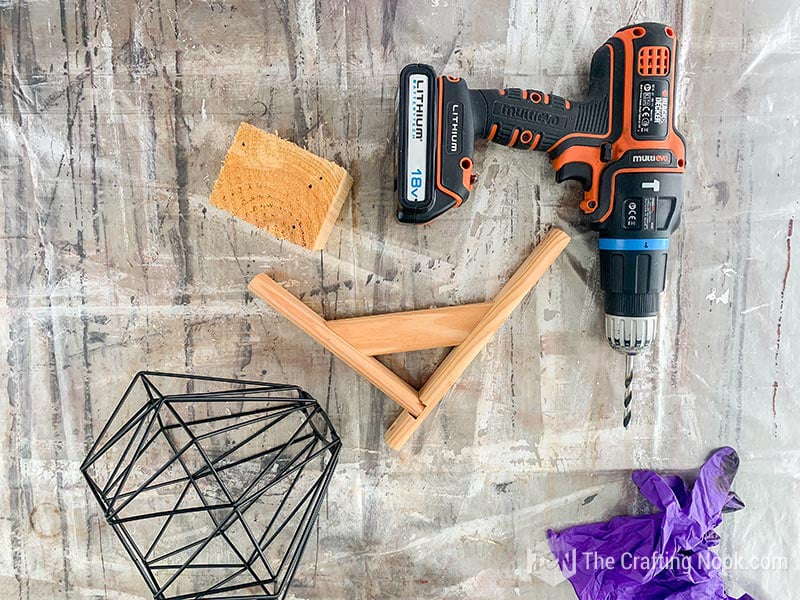 Shelf bracket, wooden block and drill ready to open a hole