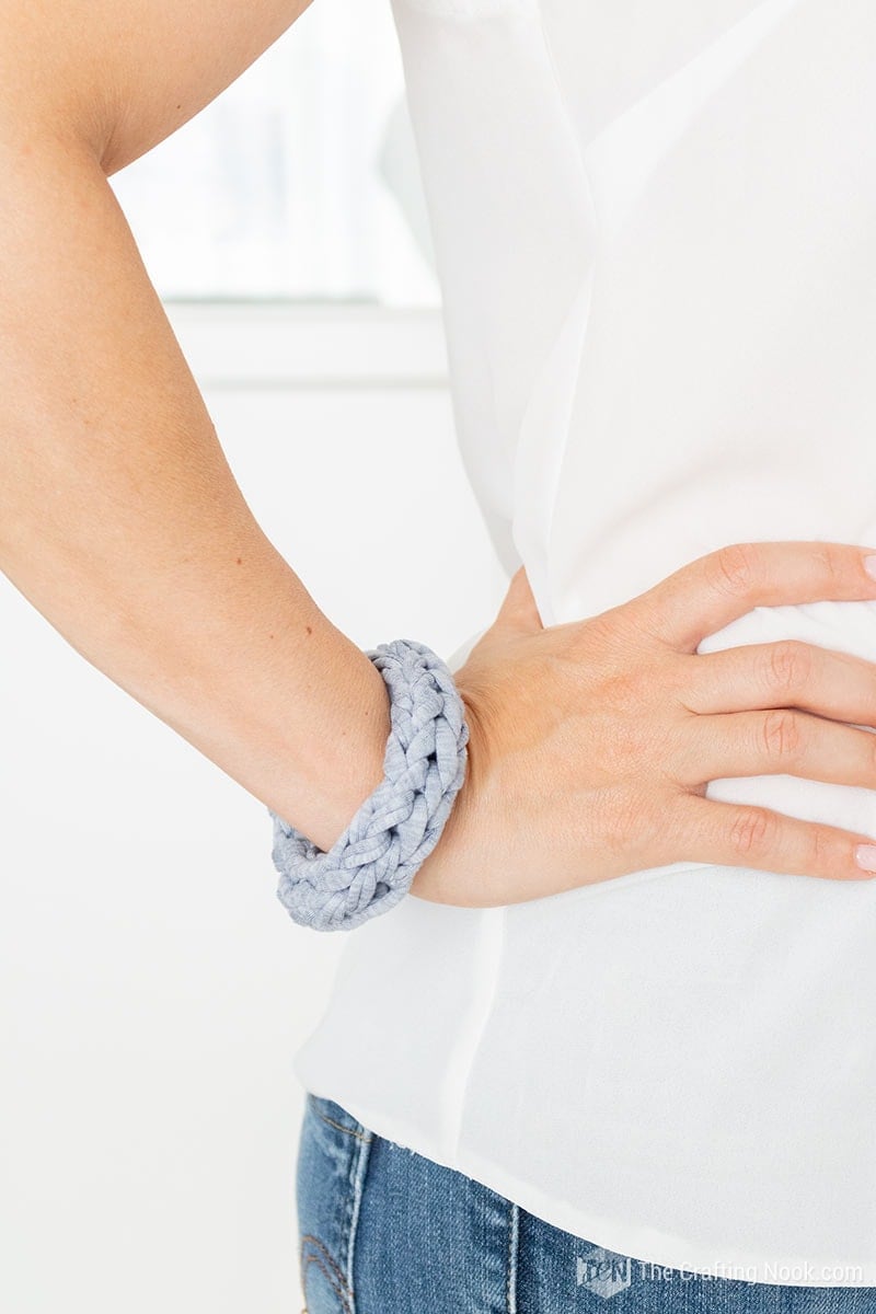 Me with my hand on my hip showing the 4 fingers knitted bracelet. color grey