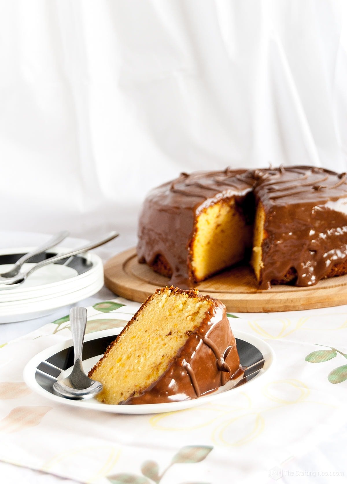 Easy Orange Cake Recipe covered with Nutella Glaze and served on a black and white dish