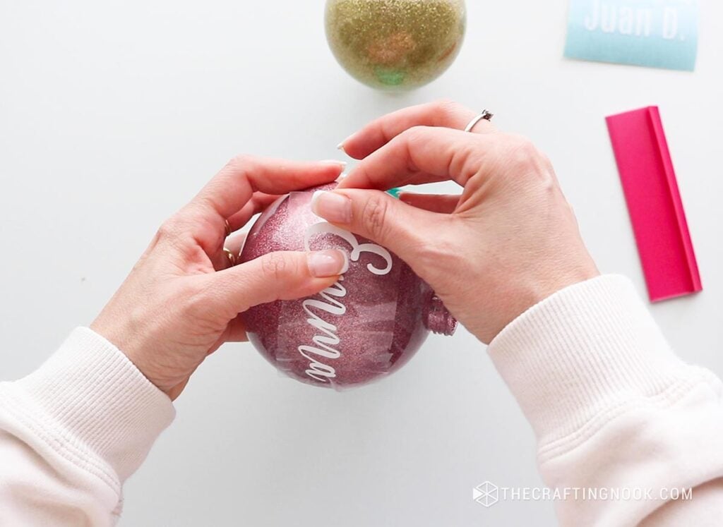 applying the Emma vinyl name on the pink ornament from the center left