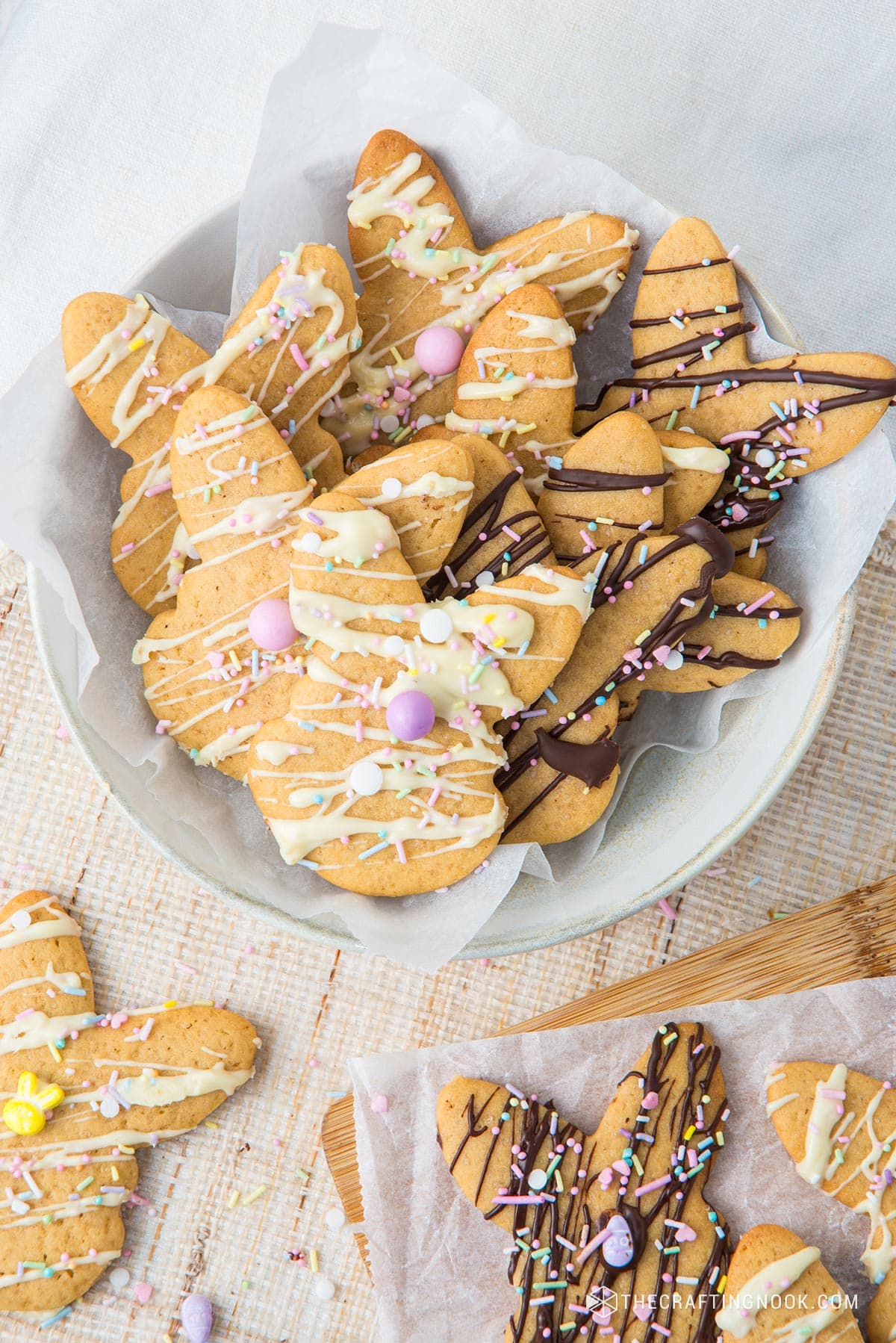 A bunch od yummy Easter bunny cookies all drizzle placed on a white bowl