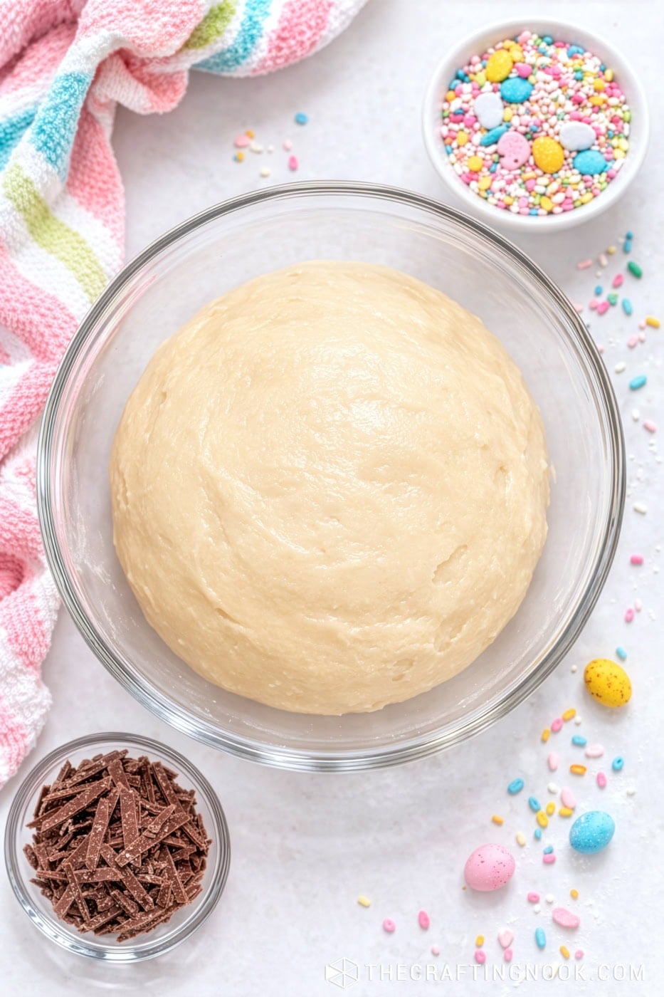 Easter Condensed Milk Truffle dough in a glass bowl with colorful sprinkles and chocolate shavings around.