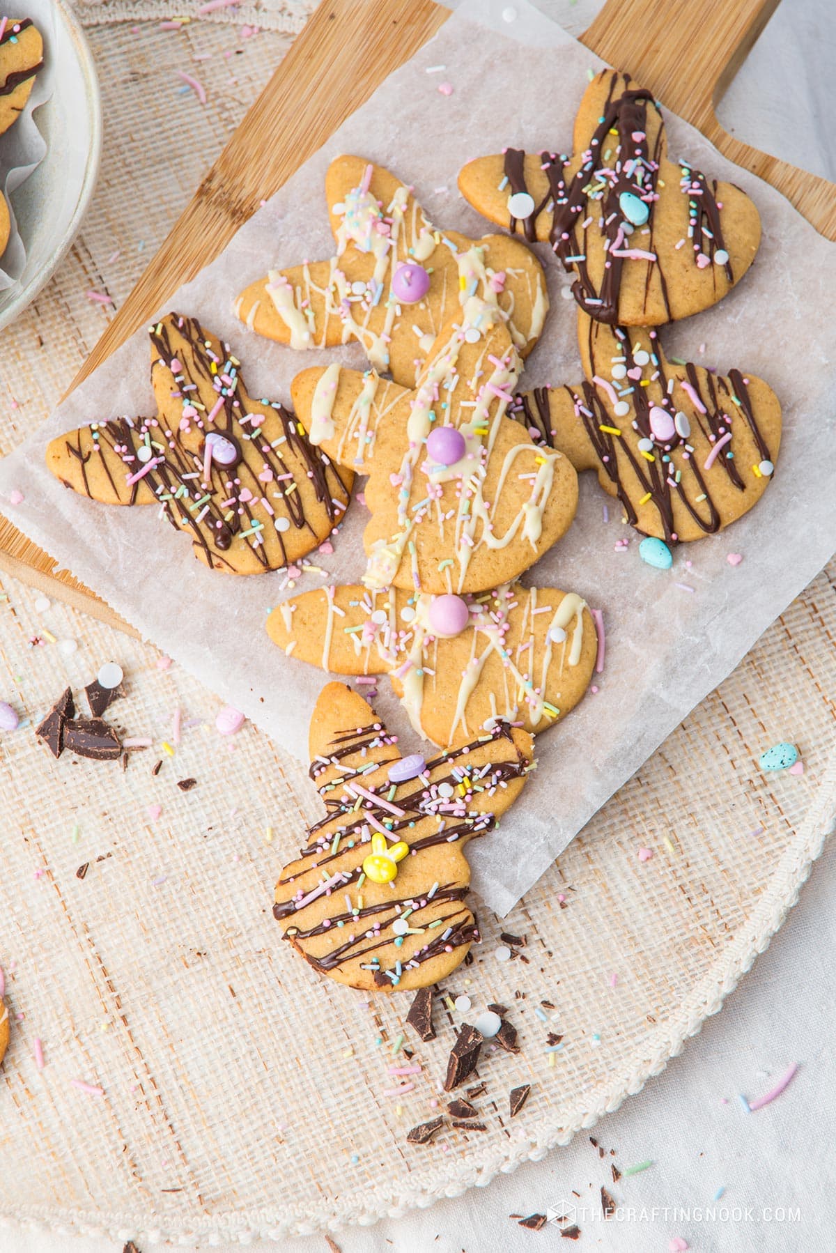 Closeup of some Easy Easter Bunny Cookies drizzle with white and milk chocolate and decorated with delicious sprinkles placed om a wooden tray