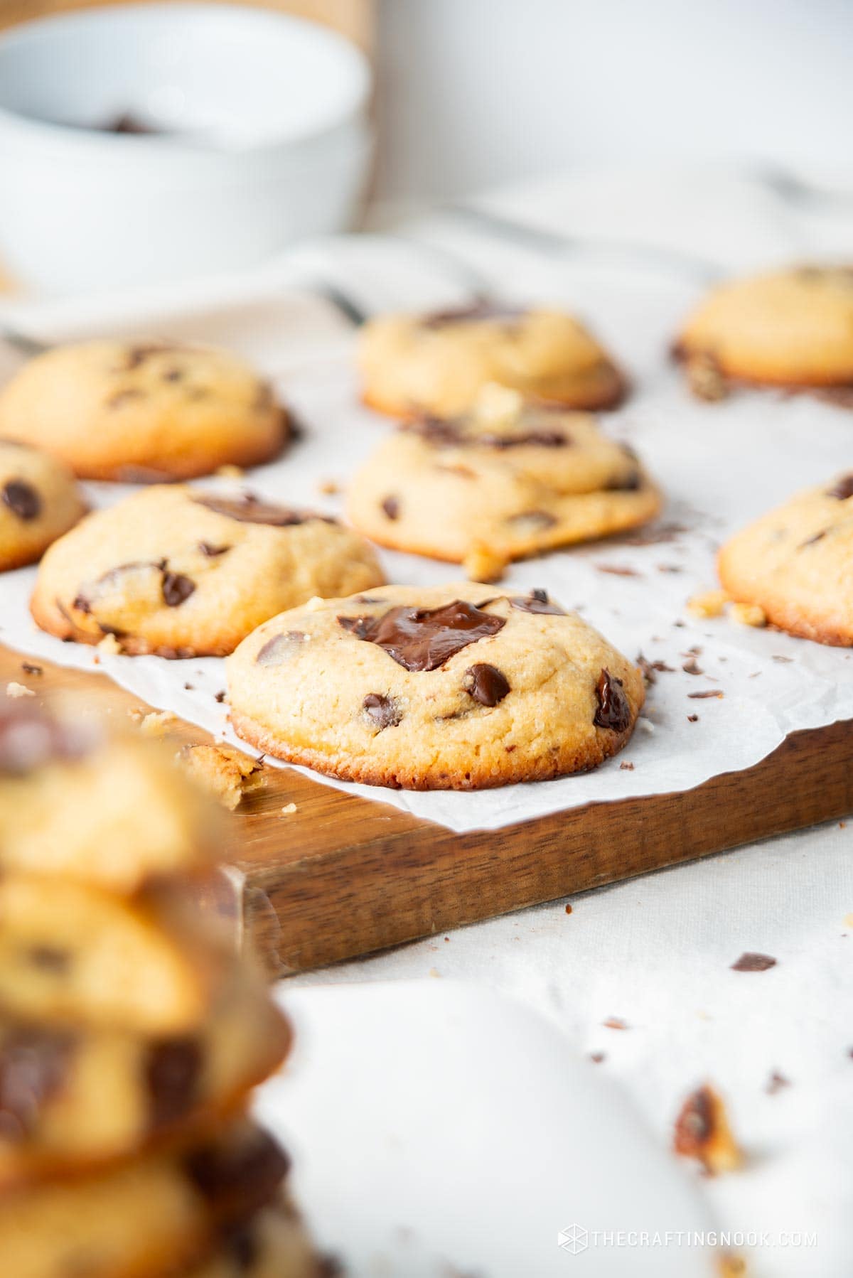 Closeup view slightly angled of the cookies on a parchment paper on a wooden cut board