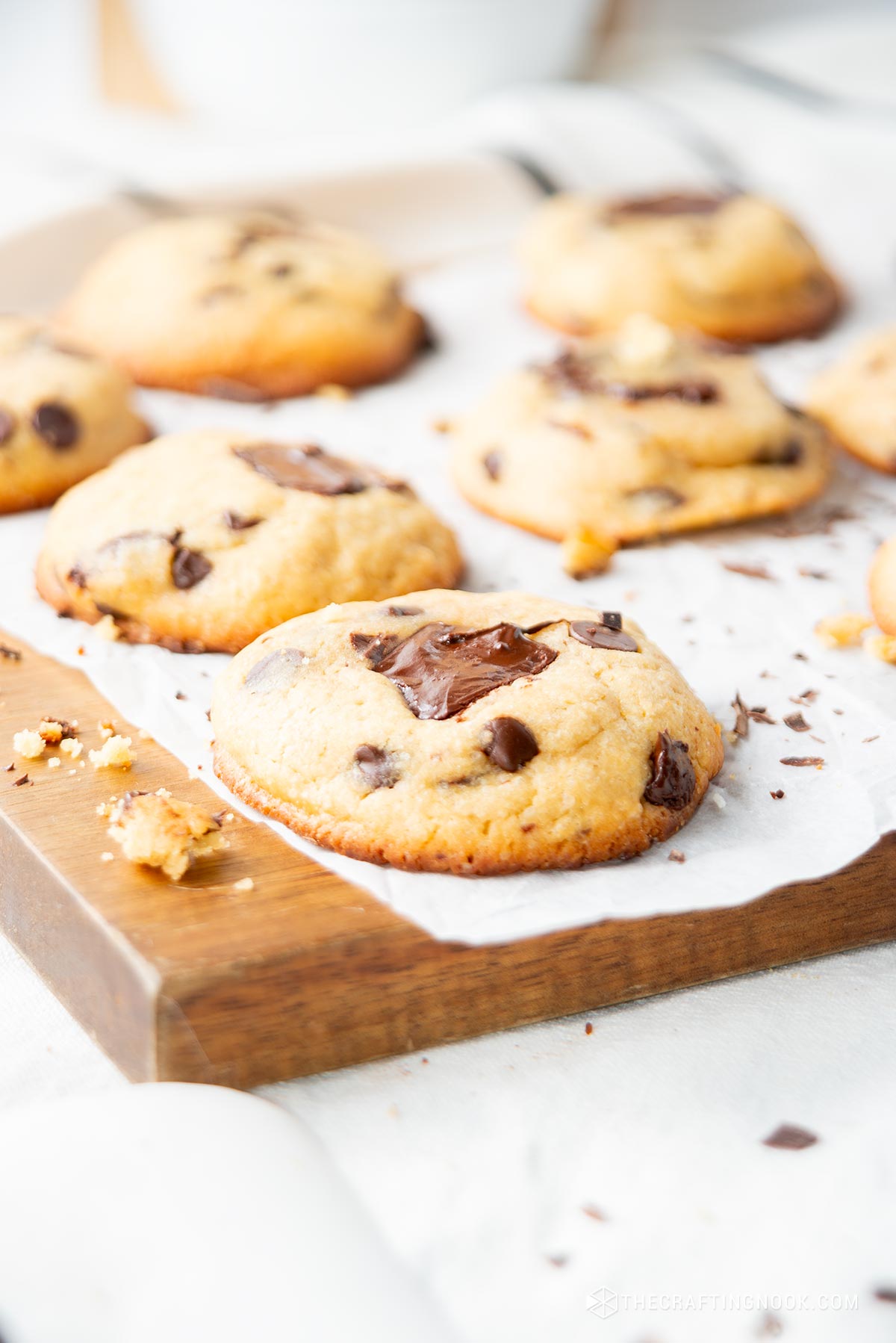 Closeup view slightly angled of the cookies on a parchment paper on a wooden cut board