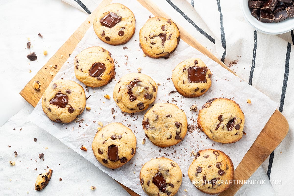 Overhead view of the chocolate chip cookies on a parchment paper on a wooden cut board