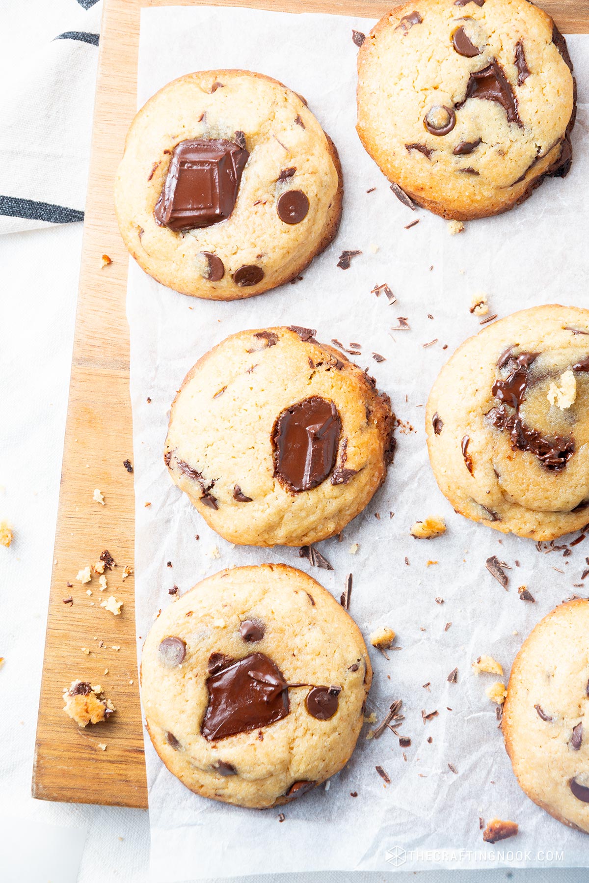 Overhead close view of the cookies on a parchment paper on a wooden cut board