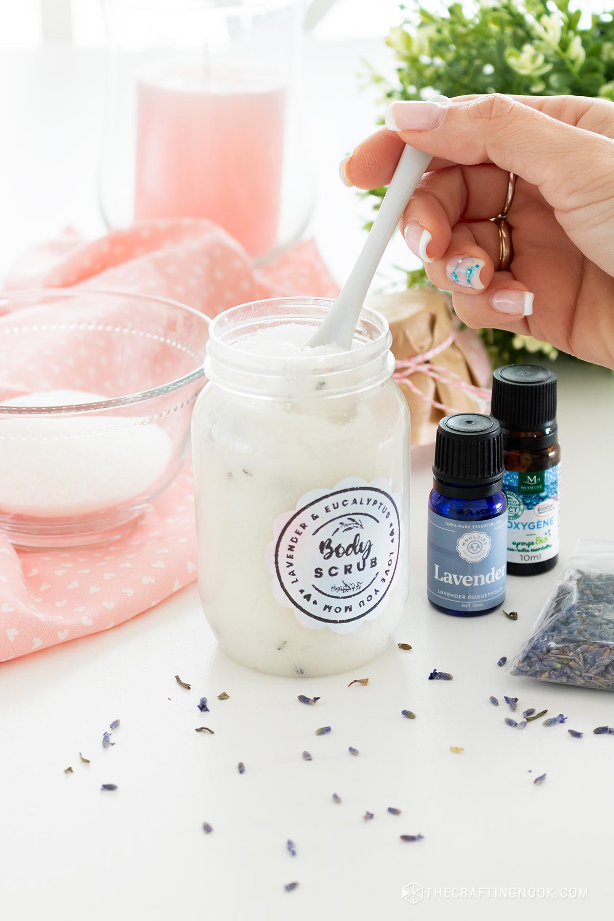 The Eucalyptus Lavender Sugar Scrub Recipein the jar and a hand scooping a small scook