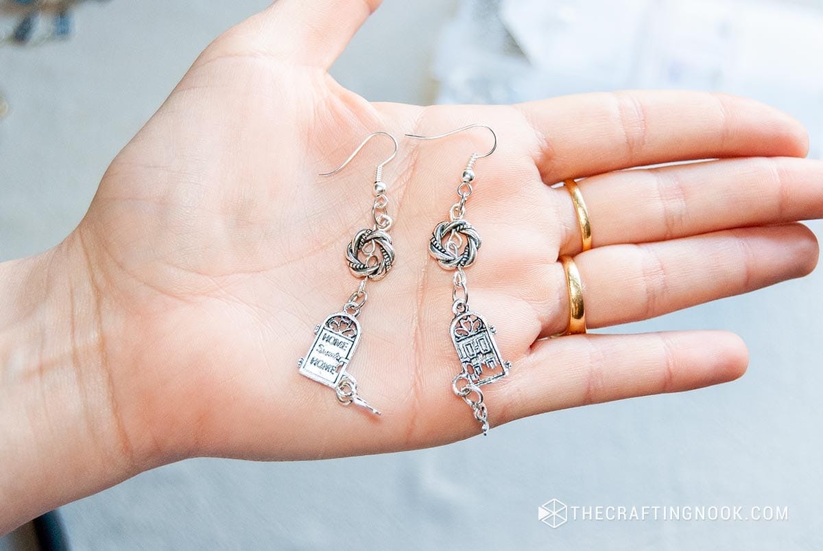 showing the finished earrings in her hand
