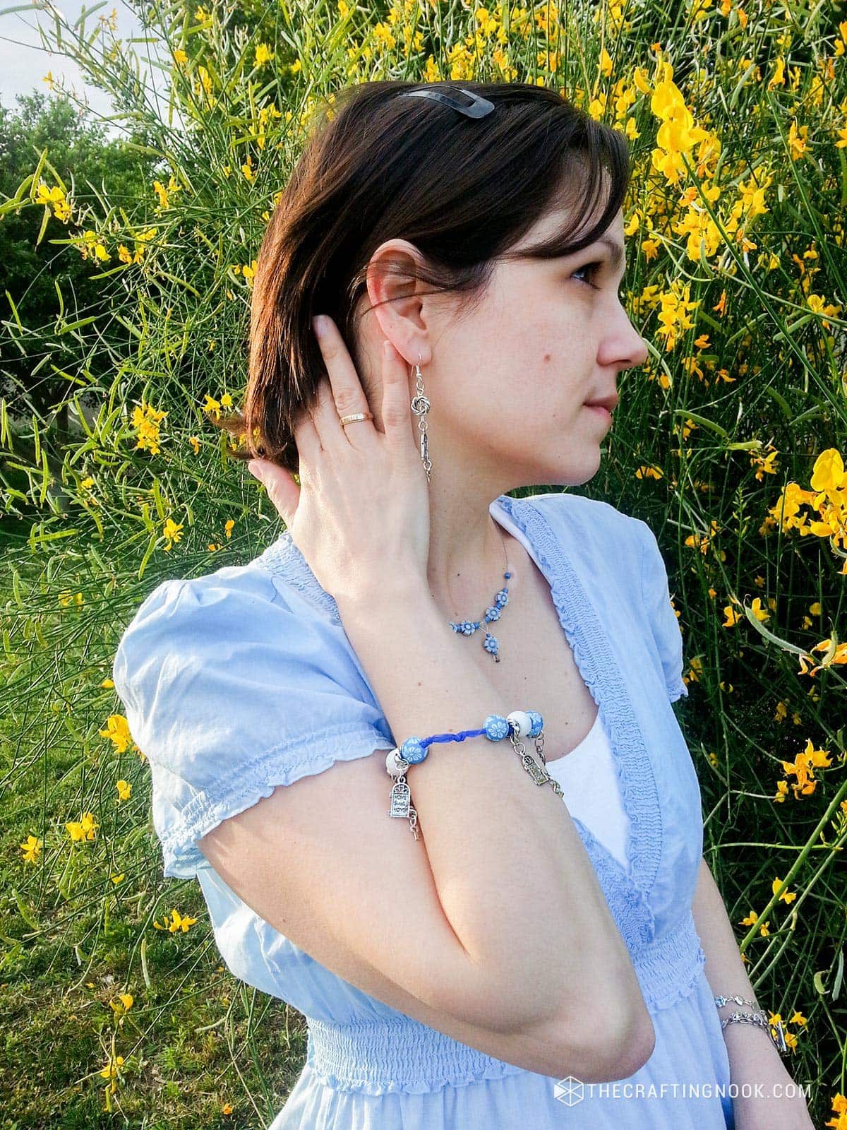 A closeup of me touching my hair and wearing my cute Beaded ribbon bracelet diy with pendants and Earrings