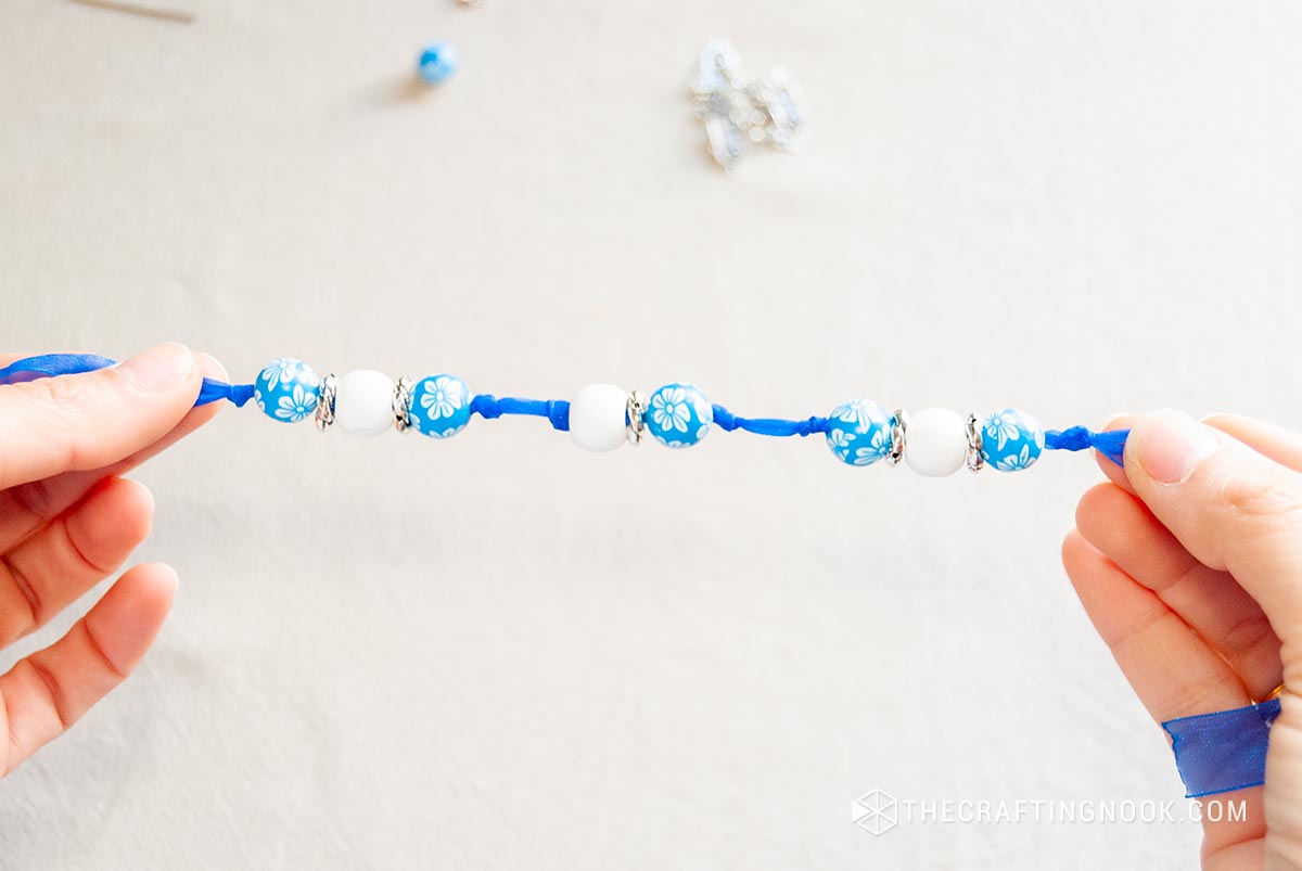 showing the pattern of the beads and knots on the almost finished ribbon
