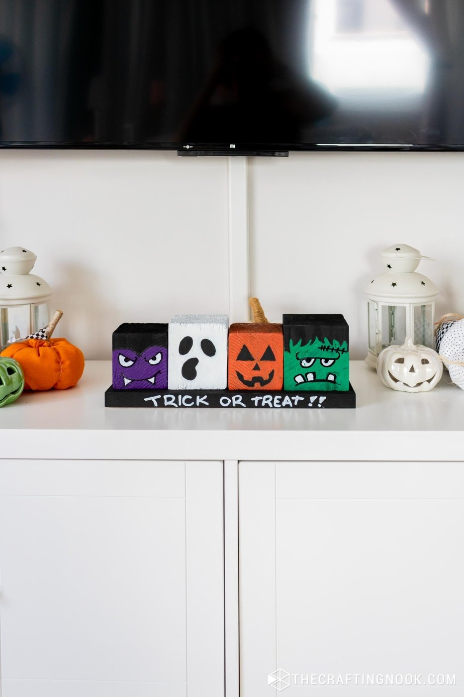 Far front view of DIY Halloween Wood Blocks in line on a wood board that say trick or treat!