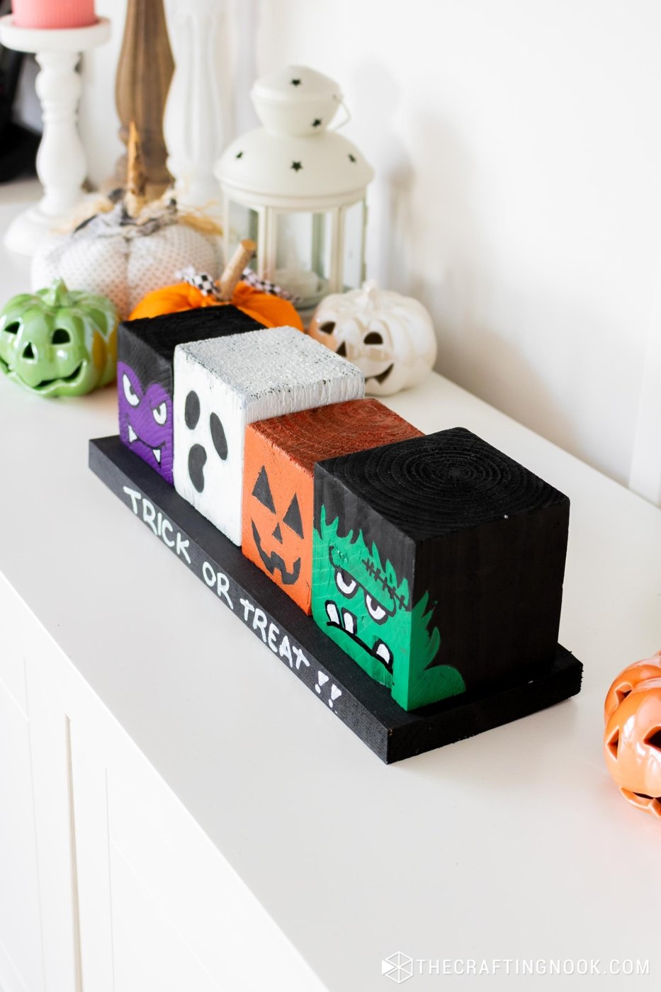 45 degree left-side-top view of DIY Halloween Wood Blocks in line on a wood board that say trick or treat!