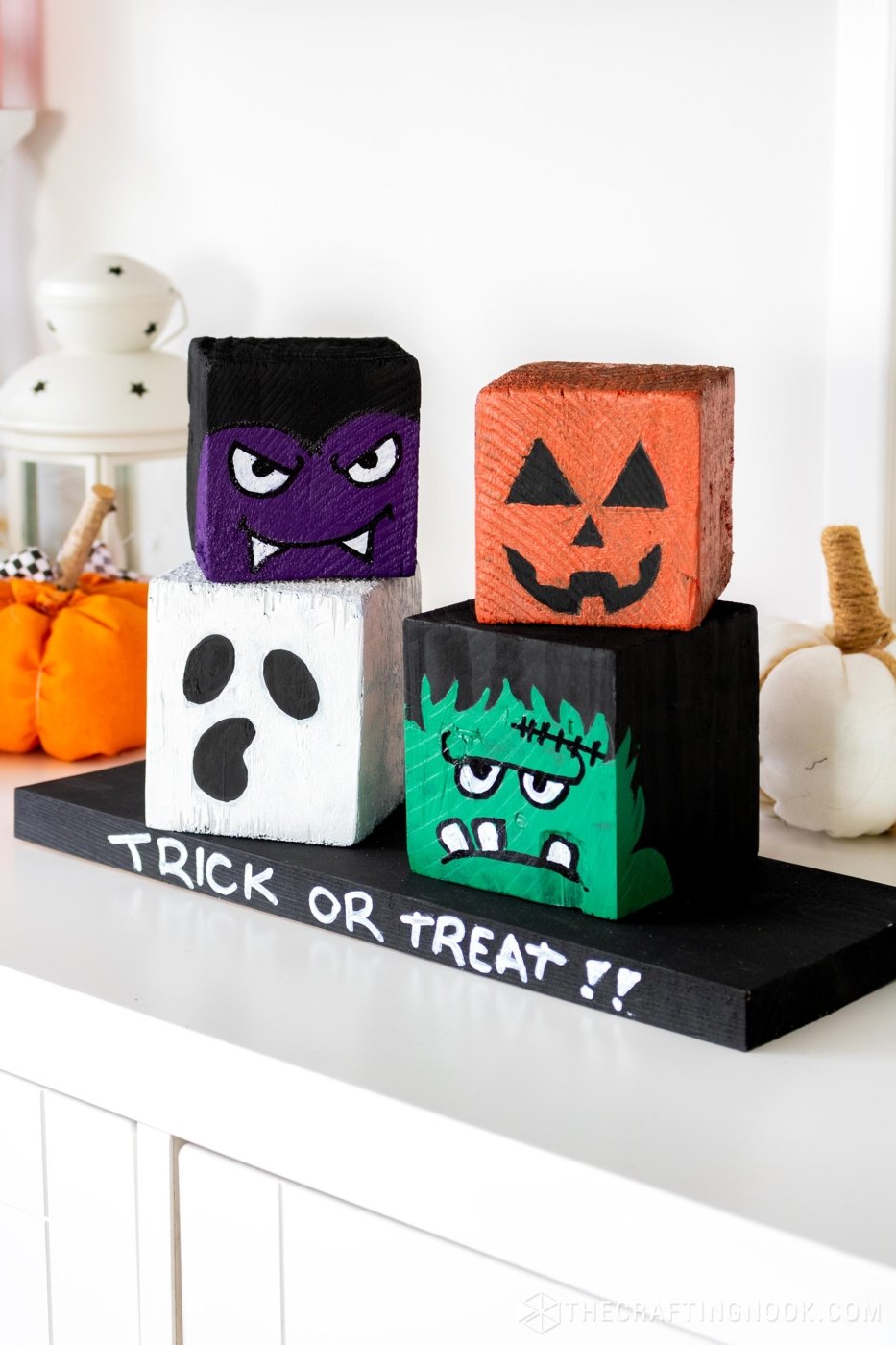 45 degree left-side view of DIY Halloween Wood Blocks stacked 2 on 2 on a wood board that say trick or treat!