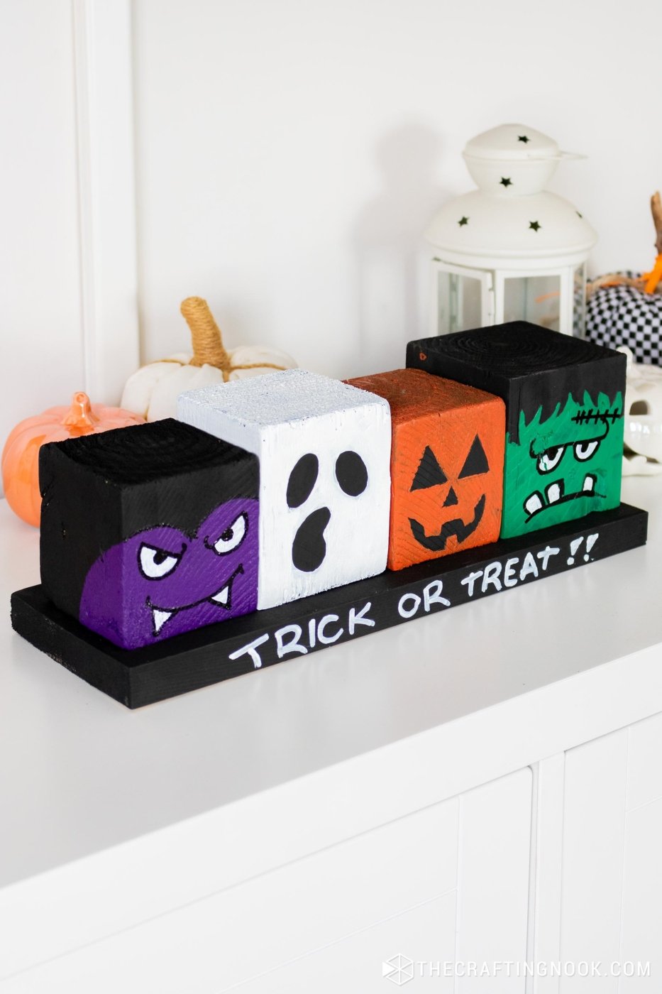 45 degree right-side close view of DIY Halloween Wood Blocks in line on a wood board that say trick or treat!