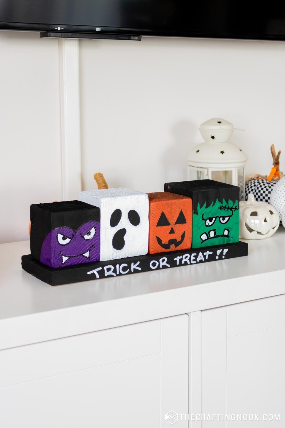 45 degree right-side view of DIY Halloween Wood Blocks in line on a wood board that say trick or treat!