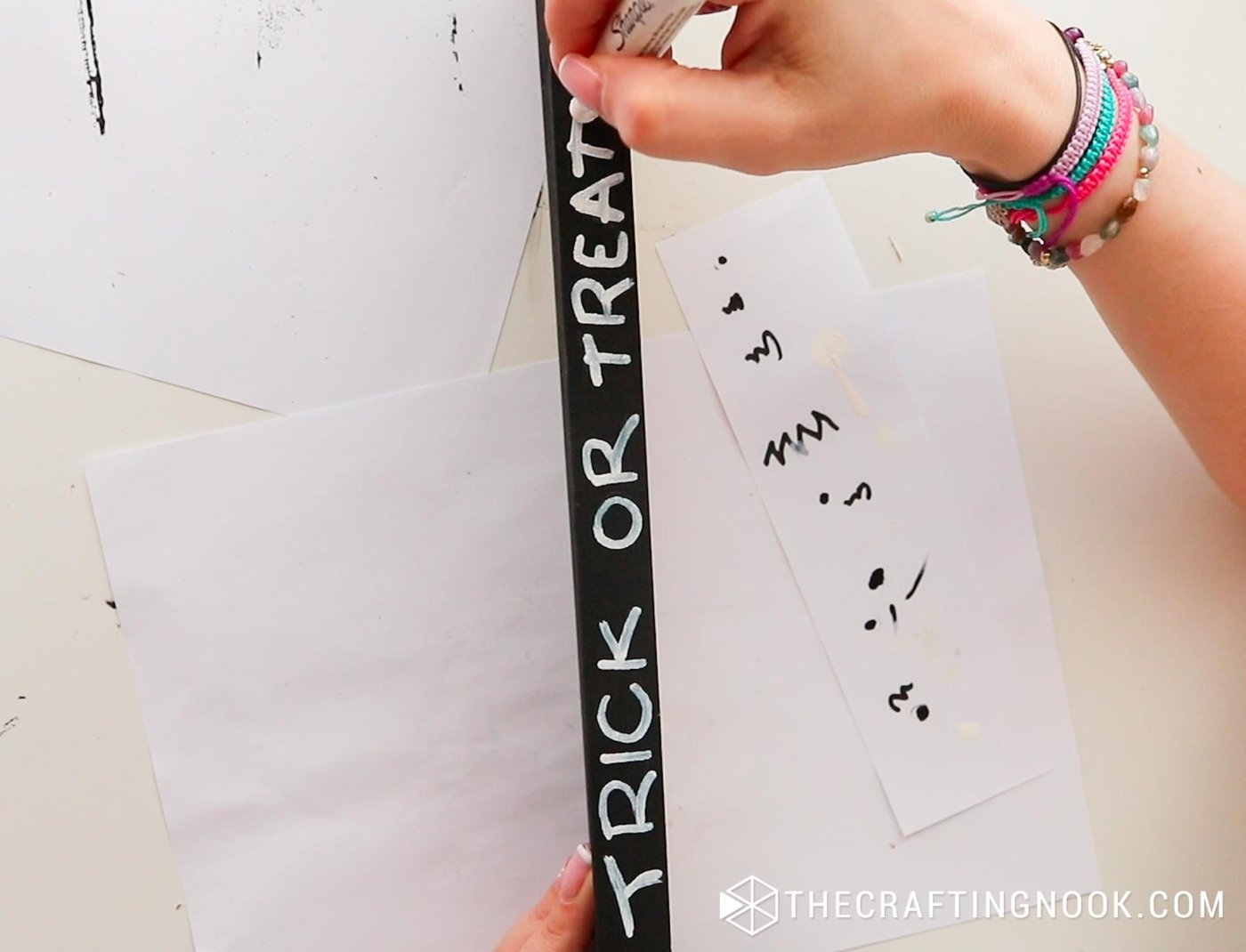 top view writing trick or treat text with a white permanent marker on the front of the display piece