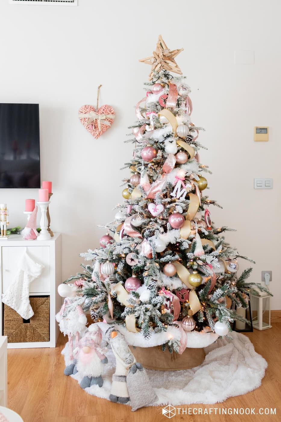 general view of the fully decorated christmas tree in pink anda white
