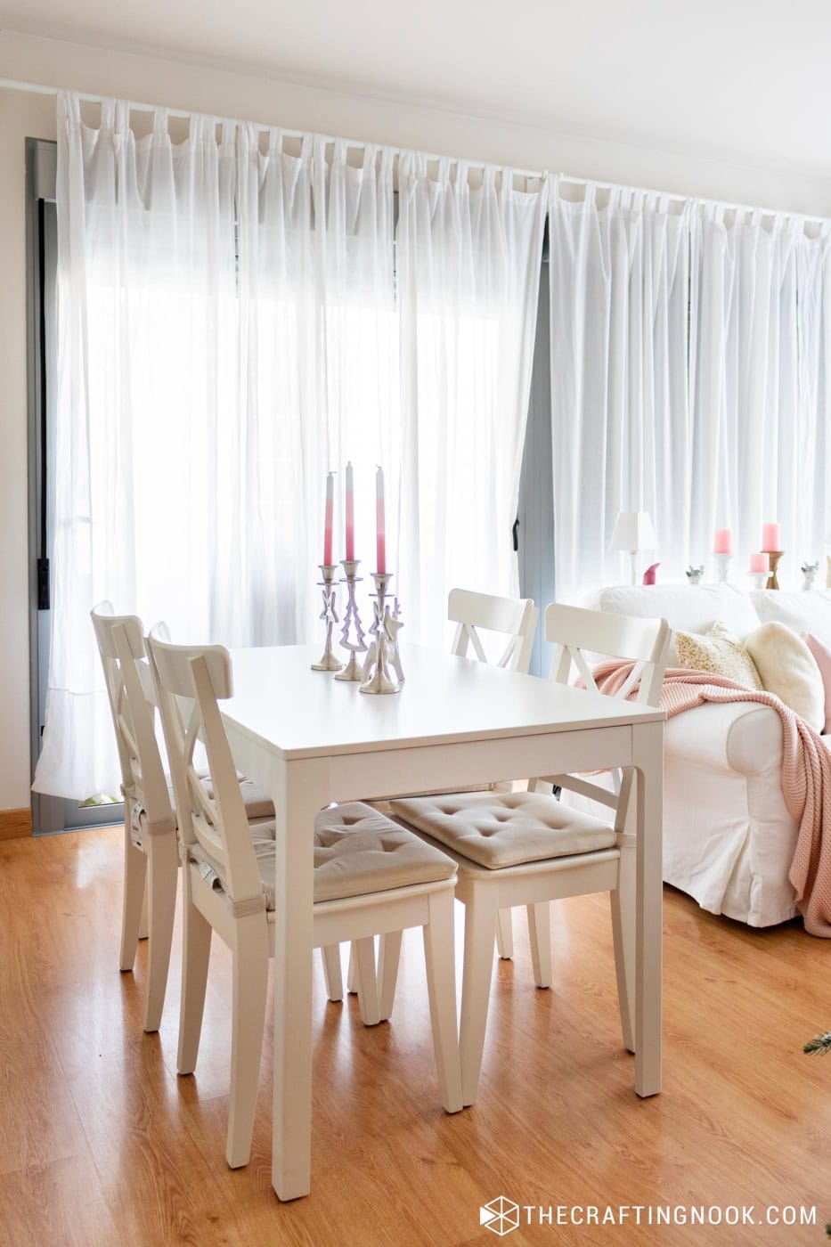 general view of the dining room with a chandelier in the center with pink candles