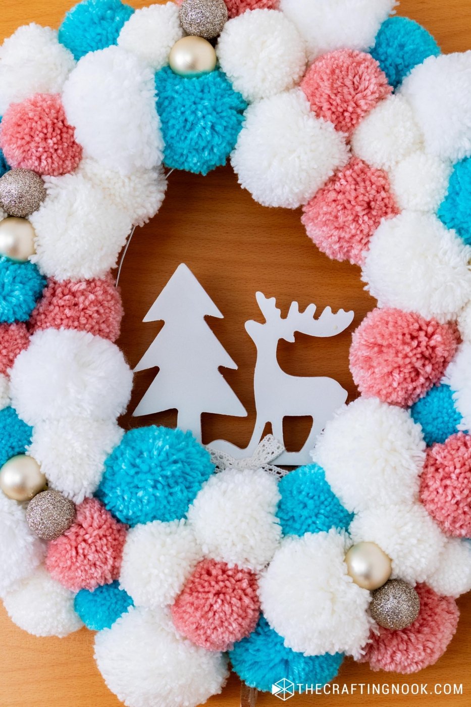 Super closeup of DIY White, Pink and Blue Pompom Wreath for Christmas hanging on the door.