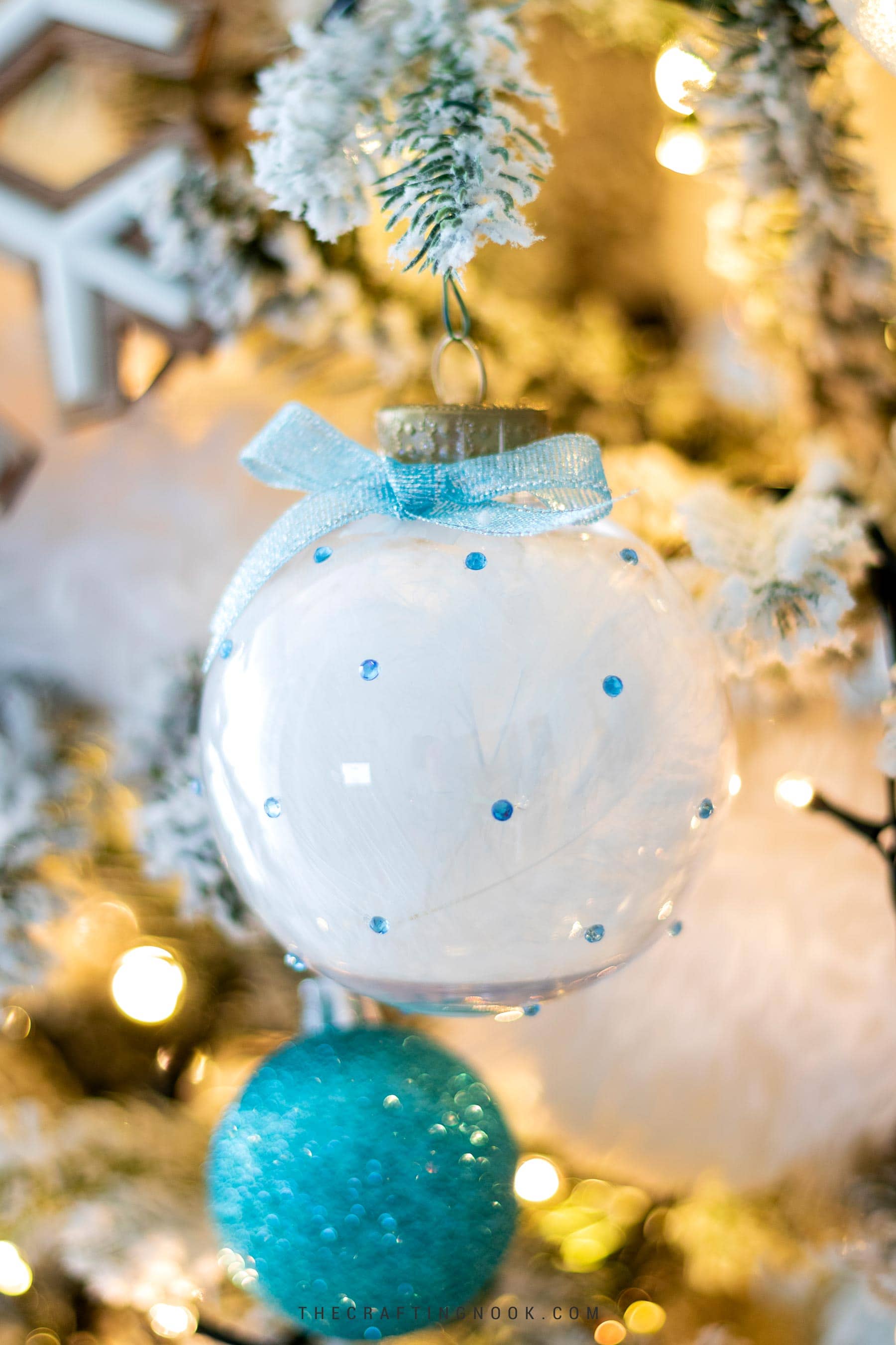 DIY Rhinestone Christmas Ornaments Filled with Feathers hanging on the tree. Cover Image