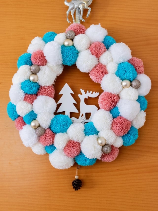 DIY White, Pink and Blue Pompom Wreath for Christmas hanging on the door. Feature Image