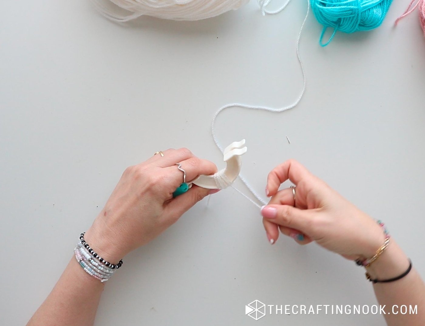 top image placing the yarn around the open pompom maker