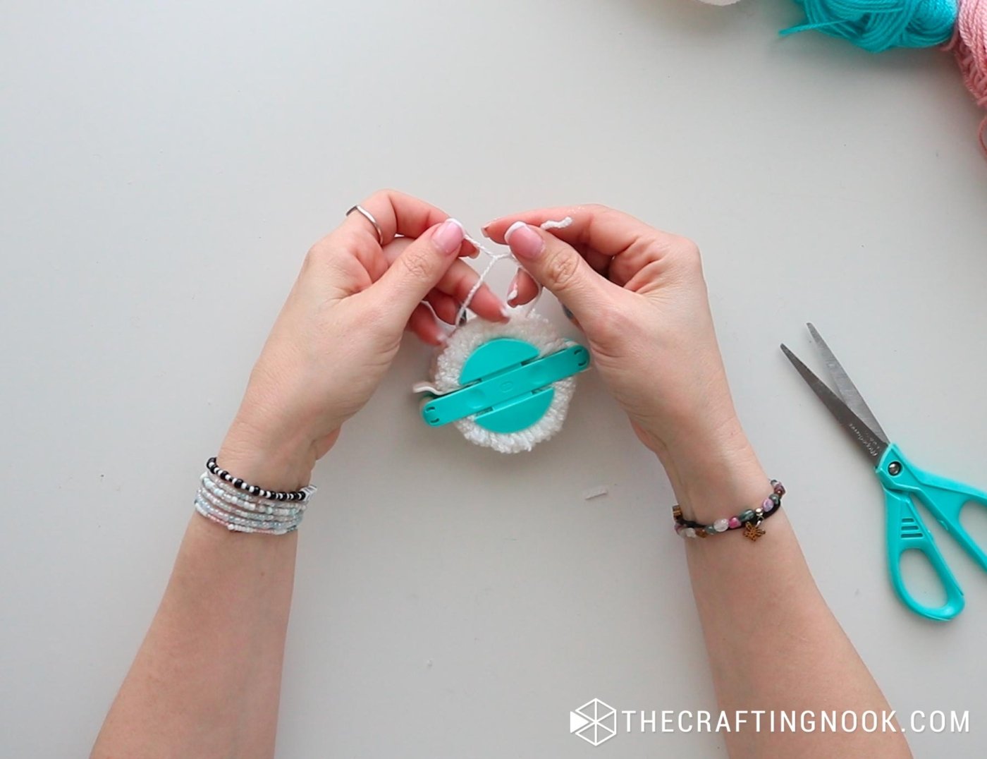 close up view making the pompom knot in half on the pompom maker
