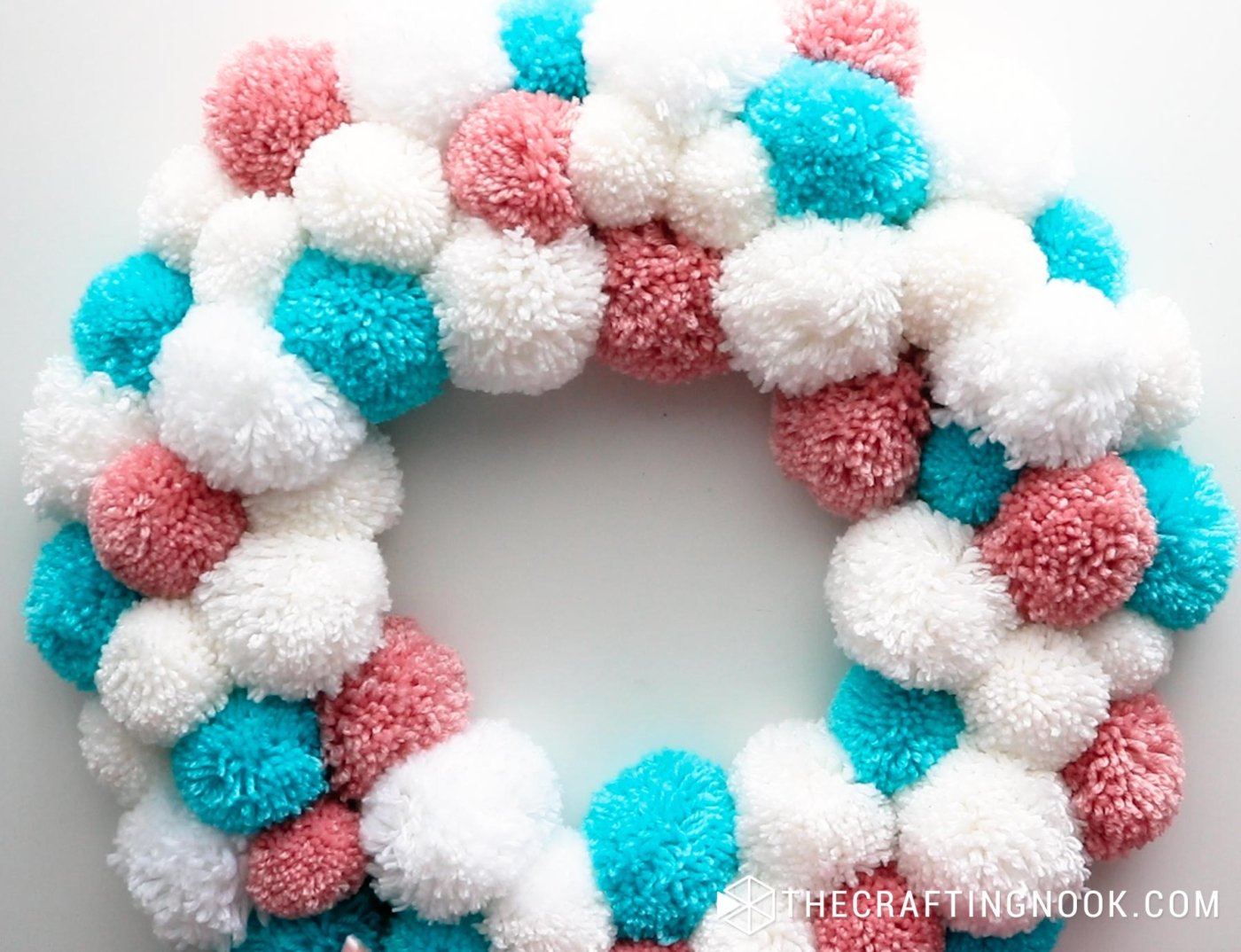 close up image of the wire wreath with all the pompoms tied
