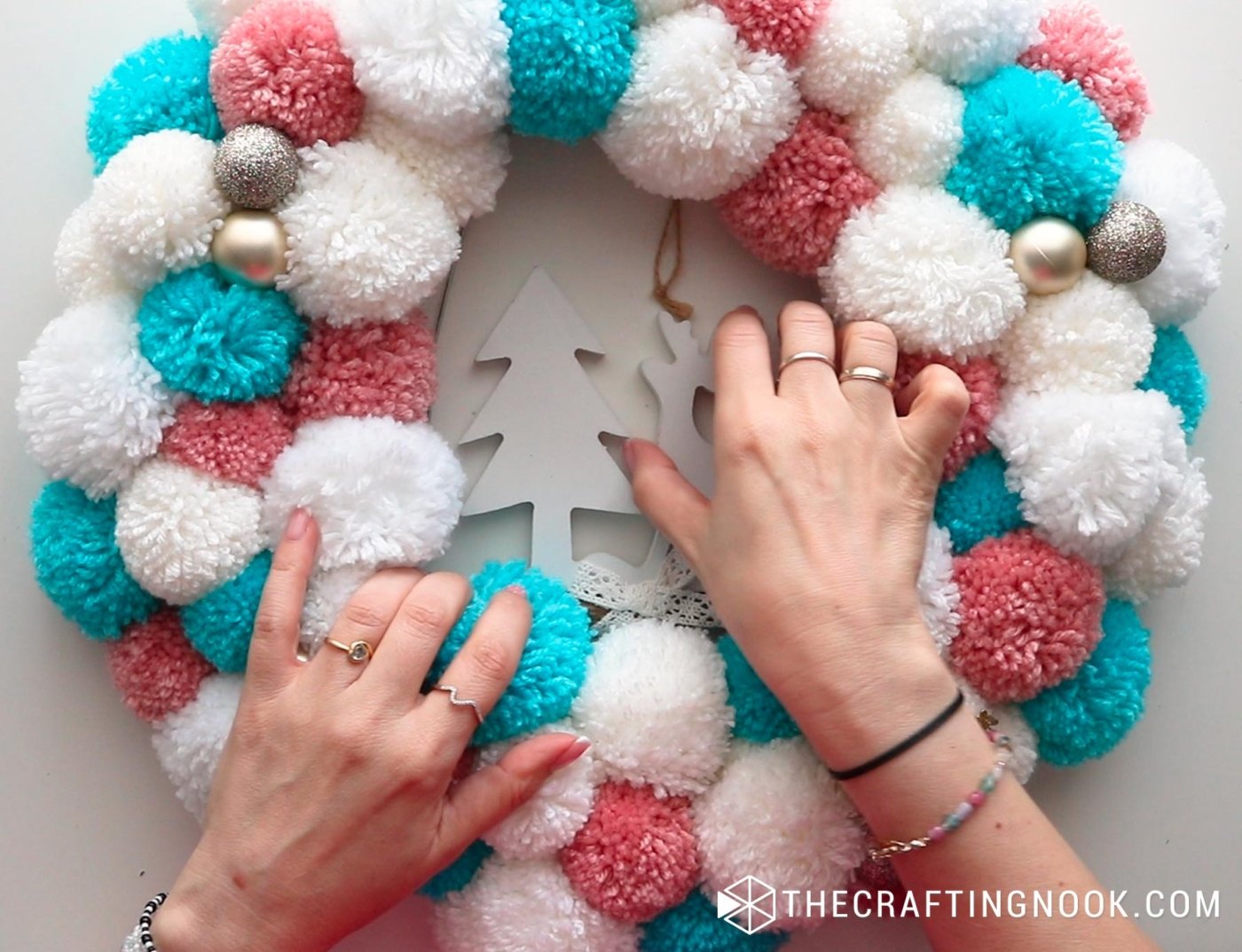 close up image of the pom pom garland and the deer hanger in the center