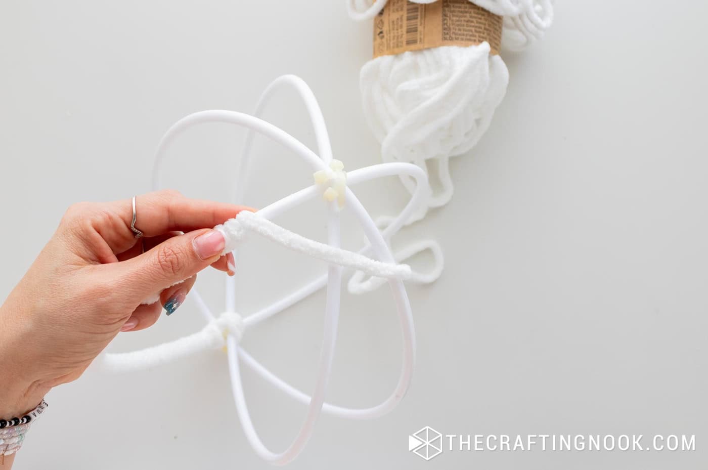 Wrapping the yarn around a joint to completely cover the zip tie.